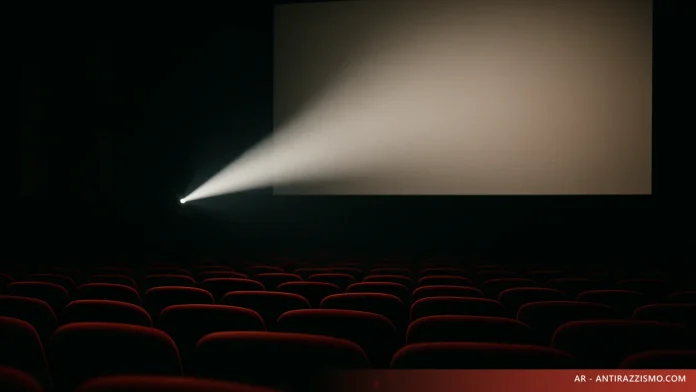 Sala cinematografica vuota con fascio di proiezione: film sul razzismo e rappresentazione